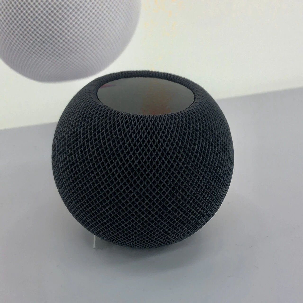 A complete dark-finish HomePod mini on display.